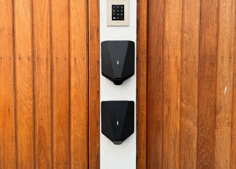 Dubbla Easee laddboxar installerade i Solna – laddstation för två bilar på träfasad.