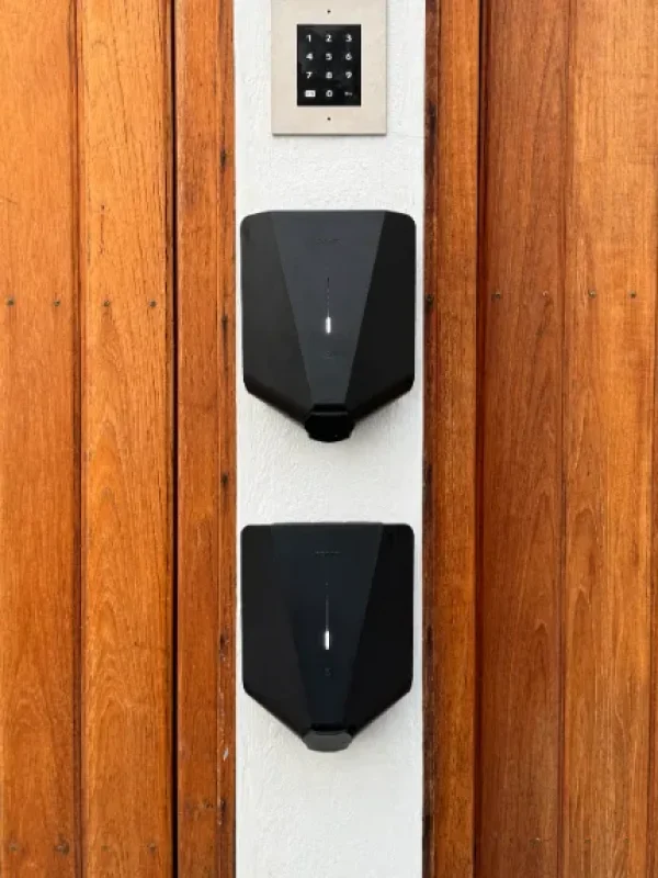 Dubbla Easee laddboxar installerade i Solna – laddstation för två bilar på träfasad.