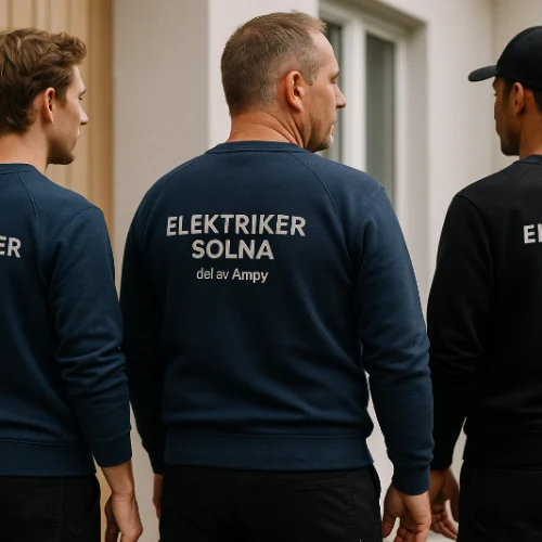 Tre elektriker från Elektriker Solna i företagskläder – står utanför en bostad och visar ryggen med logotypen tydligt synlig.